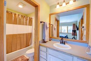 a bathroom with a sink and a toilet and a mirror at 100-2 Lakeside Village in Keystone