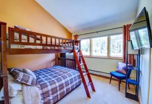 a bedroom with two bunk beds and a ladder at 100-2 Lakeside Village in Keystone