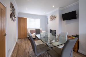 a dining room with a glass table and chairs at Pigwig Cottage, Thorpeness in Thorpeness