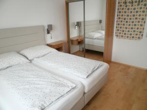 1 dormitorio con 2 camas y espejo en JOHN’S MOTEL APPARTEMENTHAUS, en Attnang-Puchheim