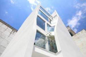 un edificio di vetro con un cielo blu sullo sfondo di Fleur Villa a Città di Hualien