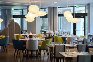 a restaurant with tables and chairs and chandeliers at Hotel Parentium Plava Laguna in Poreč