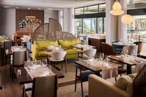 a restaurant with tables and yellow chairs and tablesktop at Hotel Parentium Plava Laguna in Poreč