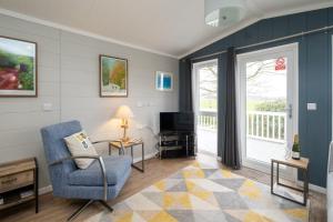salon z krzesłem i telewizorem w obiekcie Savannah Lodge - Aldeburgh Coastal Cottages w mieście Sizewell