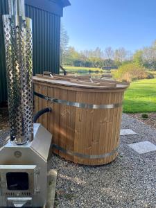 a hot tub sitting next to a grill at Heywood Glamping in Ormskirk