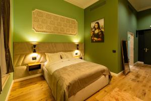 ein Schlafzimmer mit einem großen Bett mit grünen Wänden in der Unterkunft Boutique Hotel Cocosul de Aur in Târgu Mureș