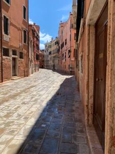 an empty street in an alley with buildings at Familly rooms (two rooms) Cà del Traghetto in Venice