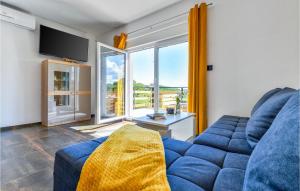 a living room with a blue couch and a large window at Nice Home In Varazdinske Toplice in Varaždinske Toplice