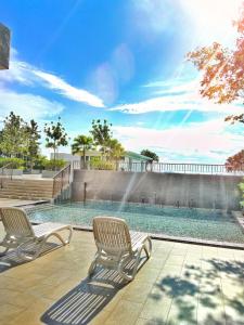 a swimming pool with two chairs next to a fence at Sara Staycation in Kajang