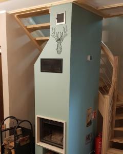 a room with a fireplace with a reindeer on the wall at Domek Dzika Konwalia 2 in Zieleniec +11 photos