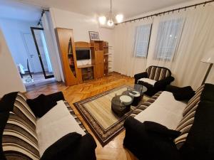 ein Wohnzimmer mit 2 Sofas und einem TV in der Unterkunft Apartment Jasovic in Ulcinj