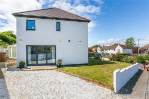 a white house with a large window and a yard at Dreghorn House 5 b-rooms 9 beds 3 toilets 2 showers,1 bath 2 receiption Secure free Parking 233 Wifi in Edinburgh