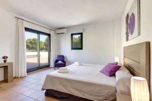 Un dormitorio con una cama grande y una silla azul. en Villa Julietta by Villa Plus, en Cala Galdana 22 fotos más