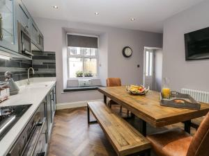 a kitchen with a wooden table and a wooden bench at The Willows in Windermere