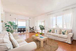 una sala de estar con 2 sofás blancos y una mesa. en Villa Antonita by Villa Plus en Cala Santandria