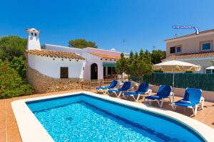 una piscina con sedie e una casa di Villa Casa Blanca by Villa Plus a Cala Blanca