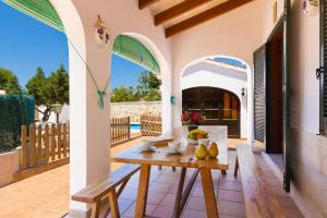 a patio with a wooden table on a house at Villa Casa Blanca by Villa Plus in Cala Blanca