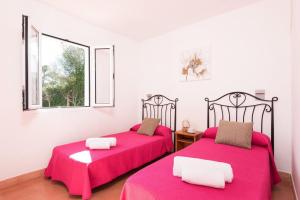 2 camas en una habitación con sábanas rosas y ventana en Villa Ses Voltes by Villa Plus, en Cala Blanca 18 fotos más