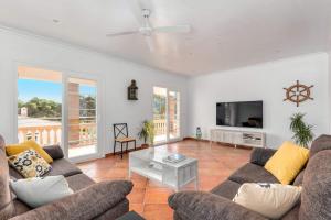 a living room with a couch and a tv at Villa Maria Isabel in Cala Blanca