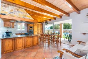 a kitchen with wooden cabinets and a table with chairs at Villa Maria Isabel in Cala Blanca