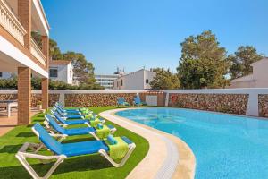 a row of lounge chairs next to a swimming pool at Villa Maria Isabel in Cala Blanca