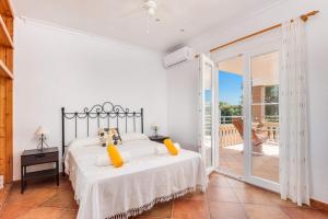 a bedroom with a bed and a balcony at Villa Maria Isabel in Cala Blanca +21 photos