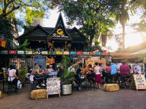a group of people sitting at tables in front of a restaurant at Parklands Shade Hotel in Nairobi