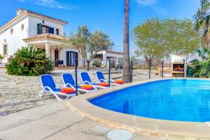 a villa with a swimming pool and lounge chairs at Villa Can Idu by Villa Plus in El Port