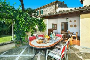 eine Terrasse mit einem Tisch und Stühlen sowie ein Haus in der Unterkunft Villa Casa Pepe by Villa Plus in Pollença