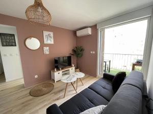 salon z niebieską kanapą i telewizorem w obiekcie T3 Expo Sud-Est - Parking - Piscine - Clim - Wifi w mieście Gruissan