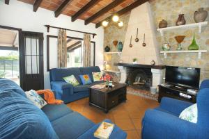 een woonkamer met blauwe banken en een open haard bij Villa Miguel by Villa Plus in El Port