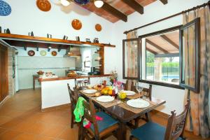 een eetkamer met een tafel en een keuken bij Villa Miguel by Villa Plus in El Port