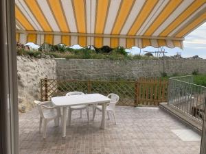 einen weißen Tisch und Stühle auf einer Terrasse in der Unterkunft Residence Andrea a mare in Ischia