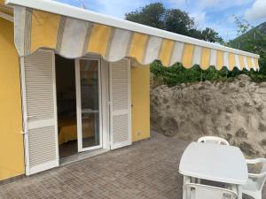 Markierung über einer Terrasse mit einem Tisch und Stühlen in der Unterkunft Residence Andrea a mare in Ischia