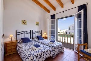 a bedroom with a bed and a large window at Villa Saona by Villa Plus in Es Mercadal +21 photos
