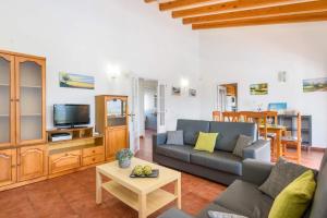 a living room with a couch and a tv at Villa Saona by Villa Plus in Es Mercadal