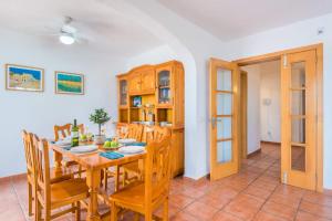a kitchen and dining room with a table and chairs at Villa Blanc Arenal by Villa Plus in Es Mercadal