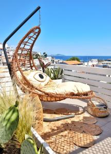 a rattan chair sitting on top of a balcony at Angelos Design Suites in Patitiri