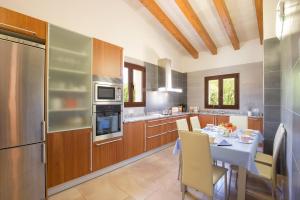 kuchnia ze stołem oraz kuchnia z lodówką w obiekcie Villa Les Pells by Villa Plus w mieście Crestatx