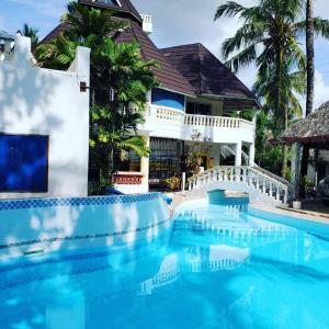 a swimming pool in front of a house at Lovely 4-Bed Villa Family oriented or a smallgroup in Diani Beach