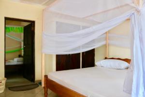 a bedroom with a bed with a canopy at 4 Bed Villa - Sleeps 8 - Wifi - Pool - Garden in Diani Beach