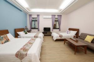 Habitación de hotel con 2 camas y sofá en 小葉園民宿Little Ya B&B, en Ruilong