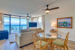 a living room with a couch and a table and chairs at K B M Resorts- VIR-1204 Penthouse Ocean Views! in Kahana