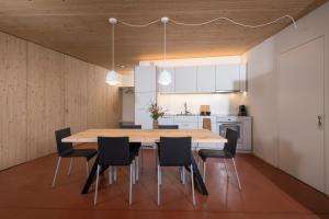 a kitchen and dining room with a wooden table and chairs at Chasa Laina in Sent