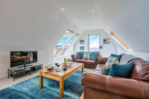 a living room with a couch and a table at Trevail Penthouse in St Ives