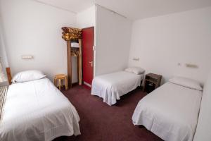 a room with two beds and a red door at Hotel Ben Centre in Amsterdam