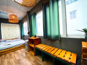 a room with a bed and a bench and windows at Cozy Room@SaiGon in Ho Chi Minh City