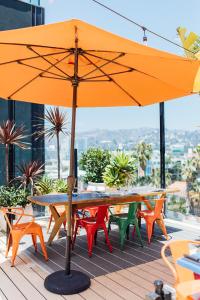 a patio area with tables, chairs, umbrellas and umbrellas at Mama Shelter Los Angeles in Los Angeles