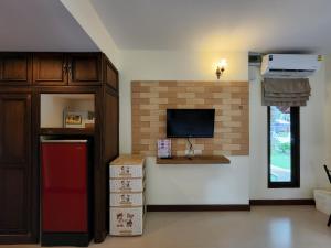een woonkamer met een televisie en een aanrecht met dozen bij La-or Resort in Hua Hin