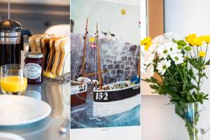 una mesa con un jarrón de flores y una foto de un barco en Wingtips en Carbis Bay